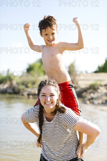 Mother carrying son (6-7) on back