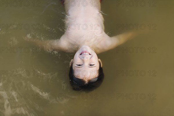 Boy (6-7) floating on water