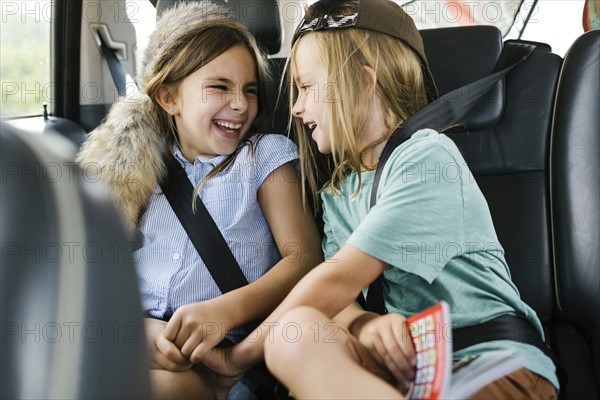 Brother (6-7) and sister ( 8-9) playing in car