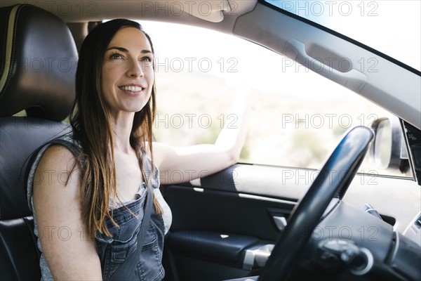 Smiling woman driving car