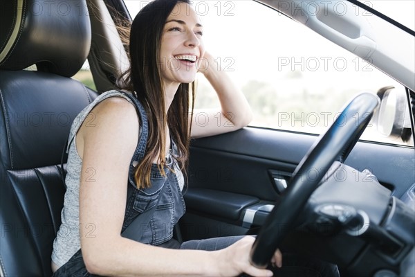 Smiling woman driving car