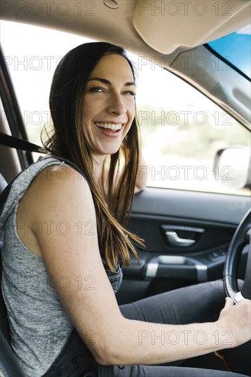 Smiling woman driving car