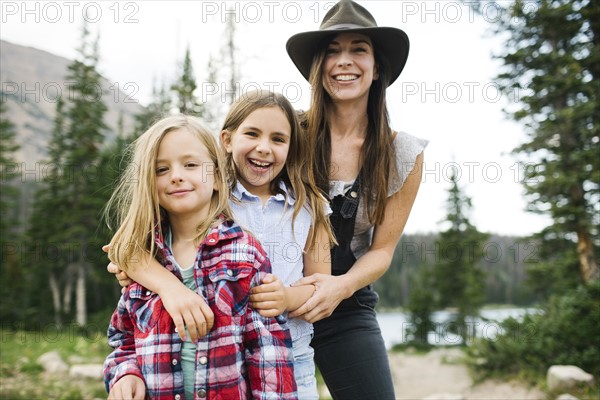 Outdoor portrait of mother with kids (6-7, 8-9) in forest