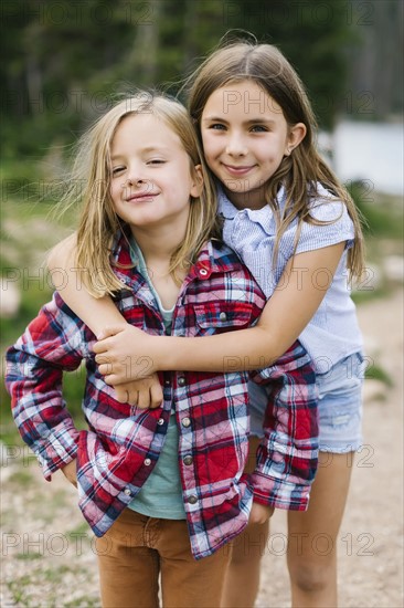 Outdoor portrait of brother (6-7) and sister ( 8-9) in forest