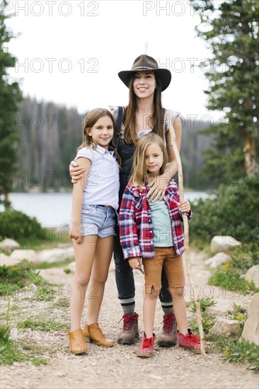 Outdoor portrait of mother with kids (6-7, 8-9) in forest