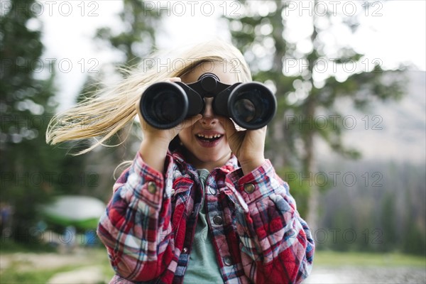 Portrait of boy (6-7) looking through binoculars