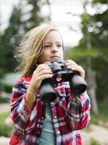 Boy (6-7) using binoculars