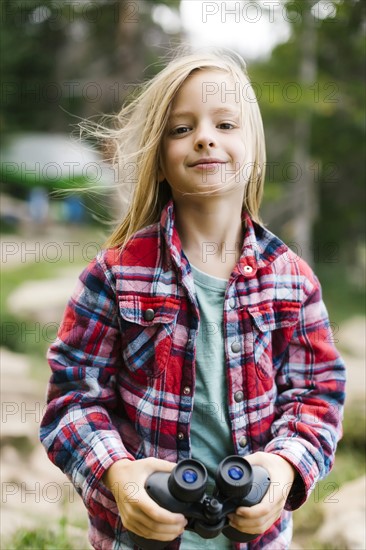 Portrait of boy (6-7) holding binoculars