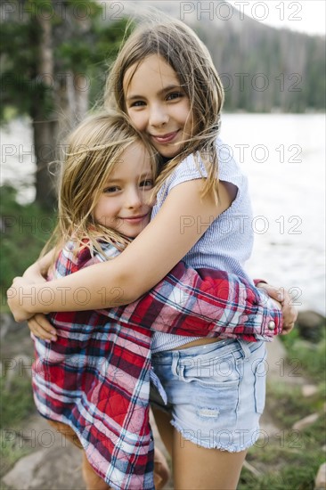 Brother and sister hugging in forest