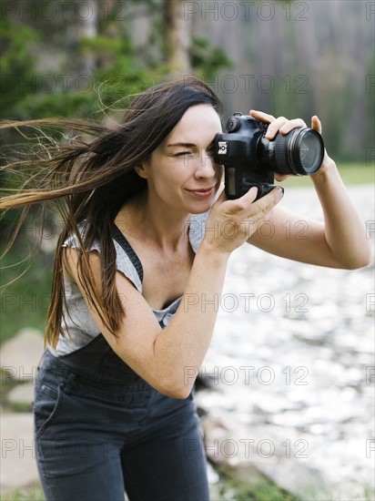 Woman taking pictures by lake