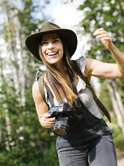 Woman with camera hiking in forest