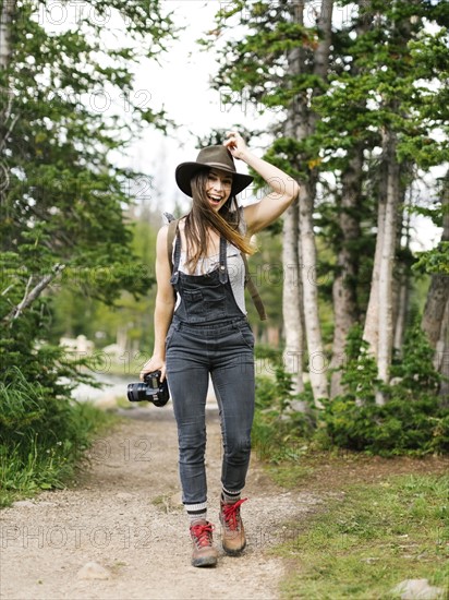 Woman with camera hiking in forest