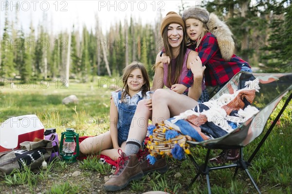 Mother with son (6-7) and daughter (8-9) camping in forest