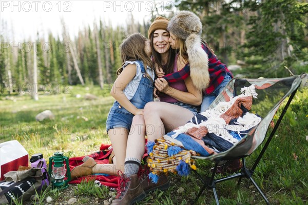 Mother with son (6-7) and daughter (8-9) camping in forest