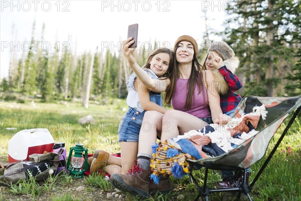 Mother with son (6-7) and daughter (8-9) camping in forest