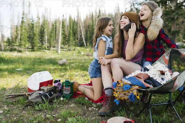 Mother with son (6-7) and daughter (8-9) camping in forest