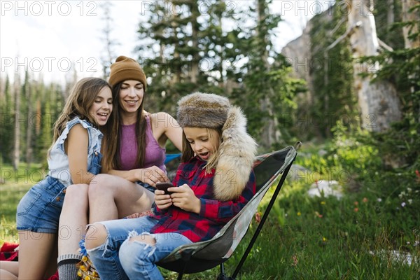 Mother with son (6-7) and daughter (8-9) camping in forest