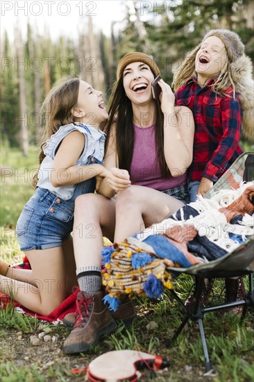 Mother with son (6-7) and daughter (8-9) camping in forest