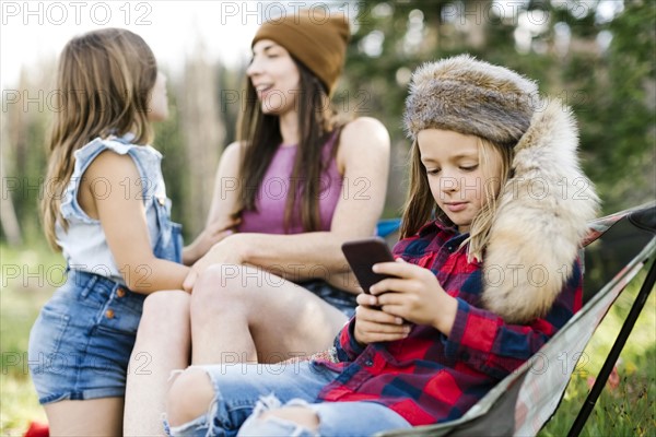 Mother with son (6-7) and daughter (8-9) camping in forest