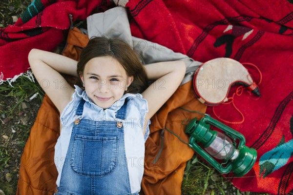 Portrait of girl (8-9) lying on blanket