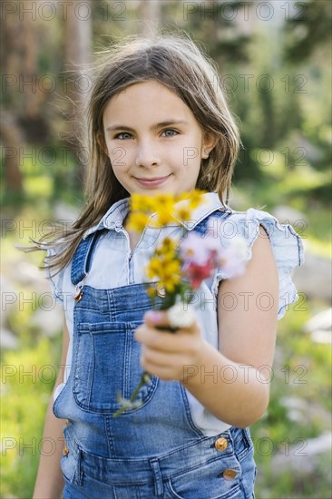 Portrait of girl (8-9) holding wildflowers