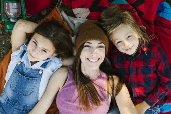 Portrait of woman with son (6-7) and daughter (8-9) lying on blanket