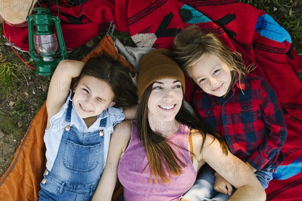 Portrait of woman with son (6-7) and daughter (8-9) lying on blanket