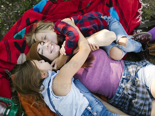 Woman with son (6-7) and daughter (8-9) lying on blanket