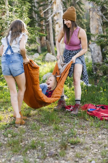 Woman playing in forest with son (6-7) and daughter (8-9)