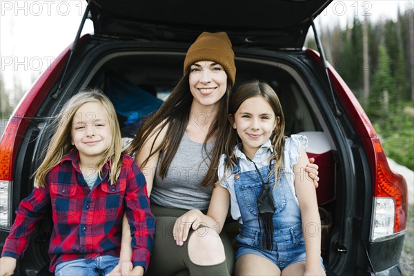 Portrait of woman with son (6-7) and daughter (8-9) in back of car