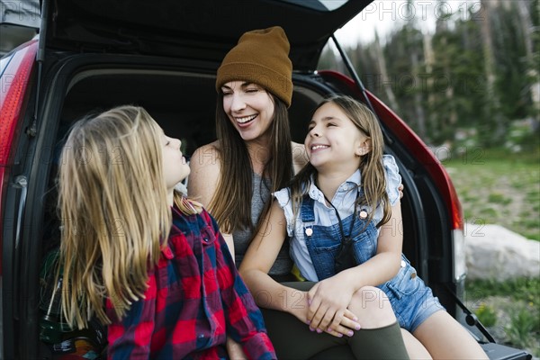 Woman with son (6-7) and daughter (8-9) in back of car