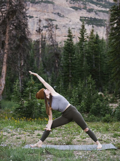 Woman practicing yoga in forest