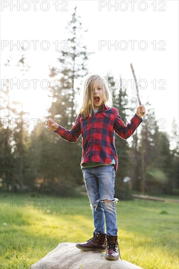 Portrait of boy (6-7) standing on rock in forest