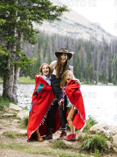 Woman with son (6-7) and daughter (8-9) standing by lake