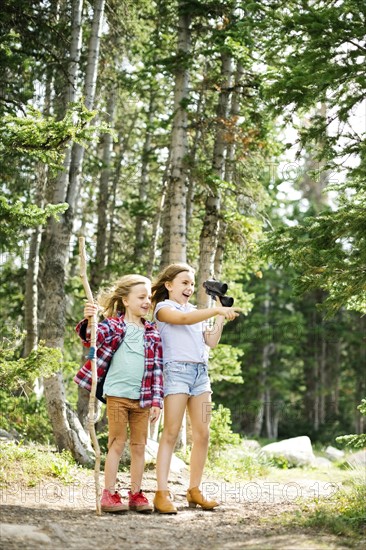 Girl (8-9) and boy (6-7) standing in forest