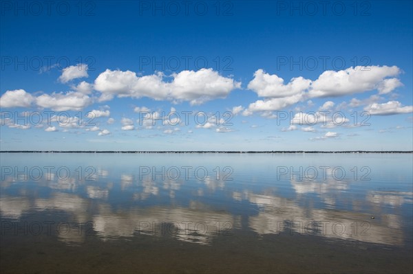 Clouds reflecting in water on sunny day
