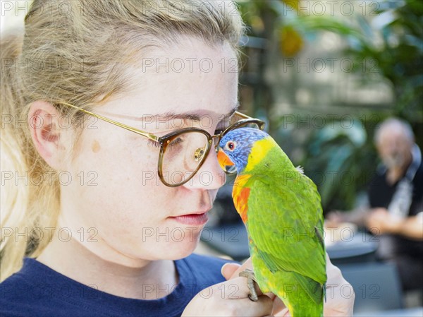 Young woman holding Rainbow lorikeet (Trichoglossus haematodus moluccanus)