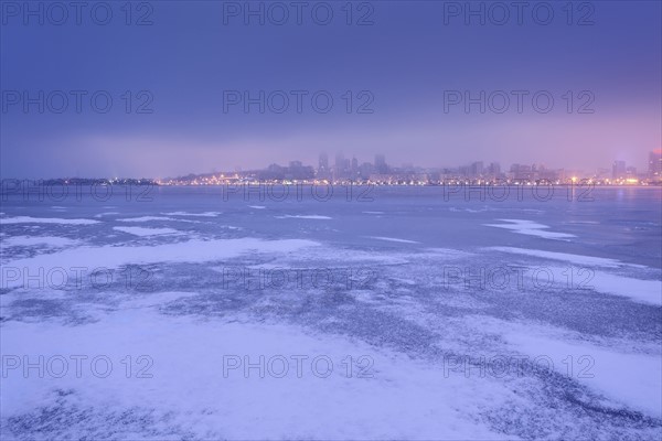 Ukraine, Dnepropetrovsk region, Dnepropetrovsk city, Dramatic sky over frozen river at dusk