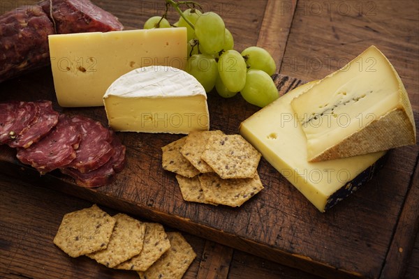 Assorted cheeses with salami and grapes