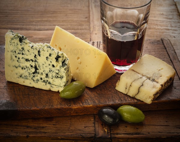 Assorted cheeses with olives and red wine