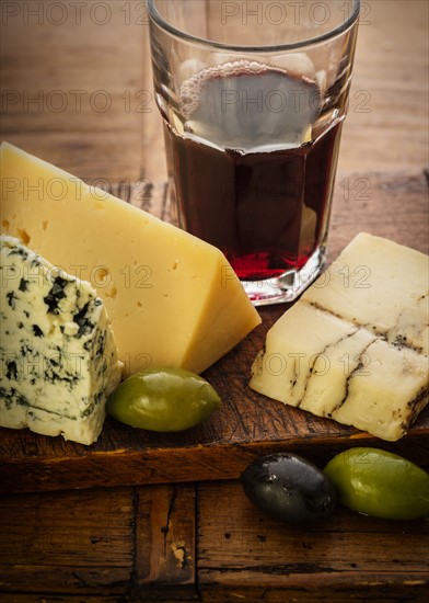 Assorted cheeses with olives and red wine