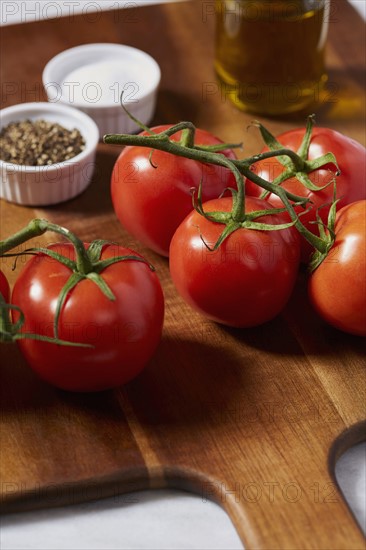 Tomatoes, pepper, salt and olive oil on cutting board