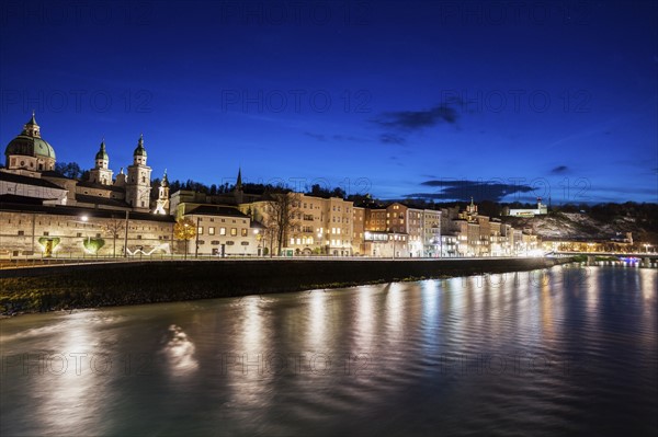 Austria, Salzburg, Riverbank with buildings at night