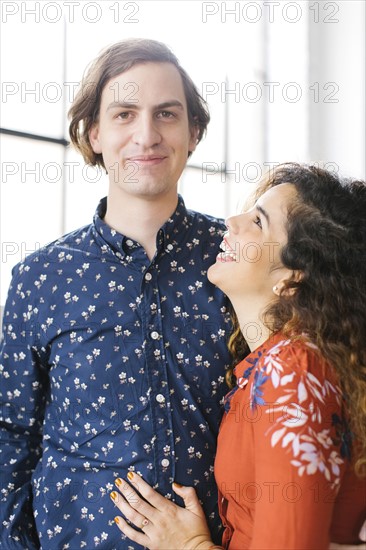 Portrait of couple against window