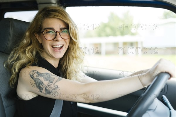 Woman driving car and laughing