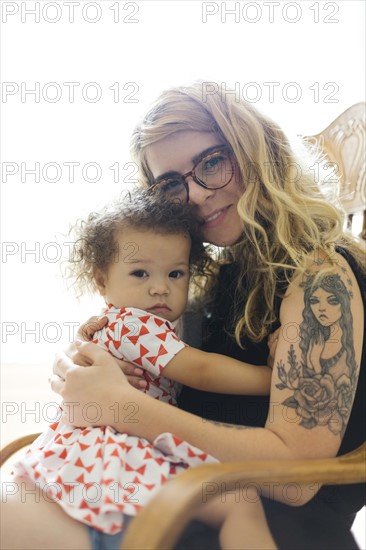 Portrait of mother and daughter (12-17) sitting on chair