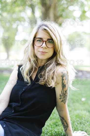 Blonde woman sitting on grass