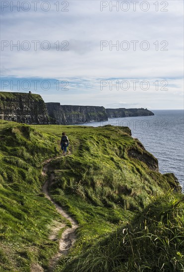 Ireland, Clare County, Woman walking along Cliffs of Moher