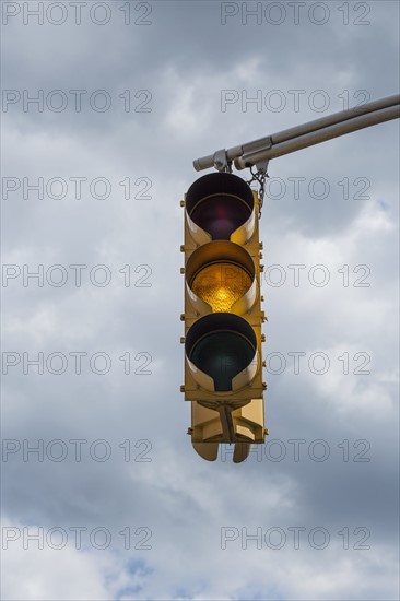Traffic light against storm clouds