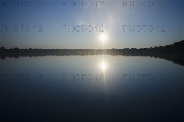 Sun rising above lake